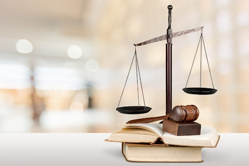 Balance représentant la justice sur des livres de lois, accompagné d'un marteau de juge en bois